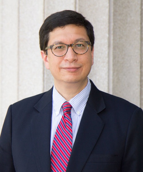 Professor Jorge Contreras, a white man with dark brown hair wearing dark-rimmed glasses and a black blazer