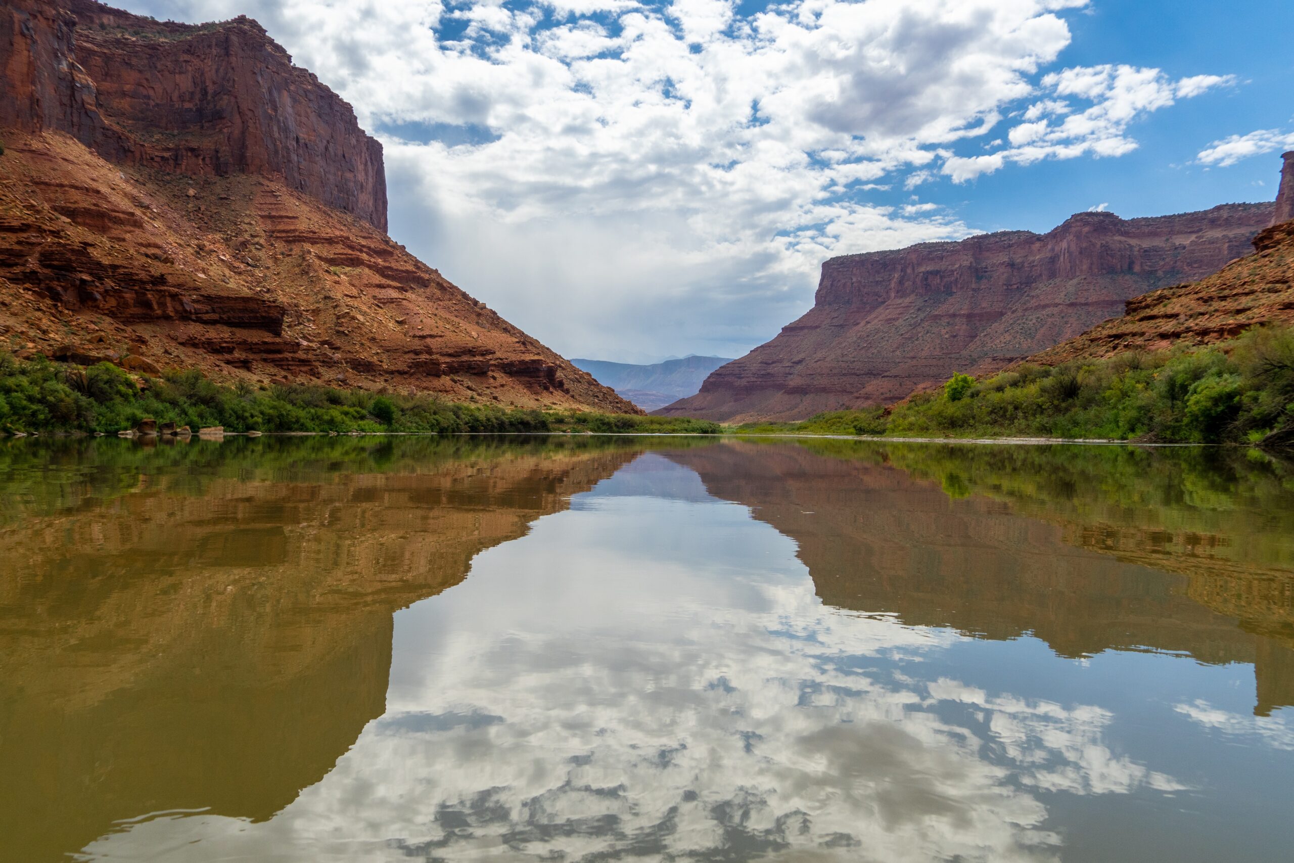 a view of the Colorado river, red canyon walls on either side of the water