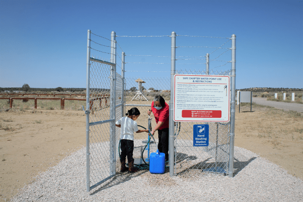 A Navajo grandmother and her granddaughter fill up water on a Navajo Indian reservation